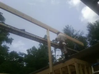 Carpenter setting a ridge beam over a new addition frame — Ice Dam Removal by Roofing Brothers in Saint Paul